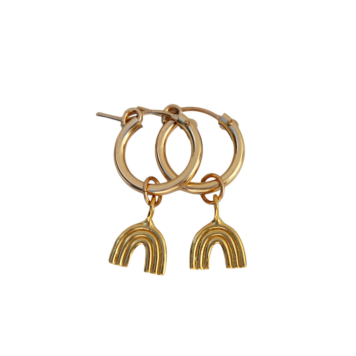 Product image of Chasing Rainbows Gold Hoop Earrings by Blooming Lotus Jewelry. These gold hoops feature a small, stylish rainbow charm that dangles below, adding a playful, whimsical touch. The simple yet elegant design makes these earrings perfect for boho-inspired and nature-loving styles.