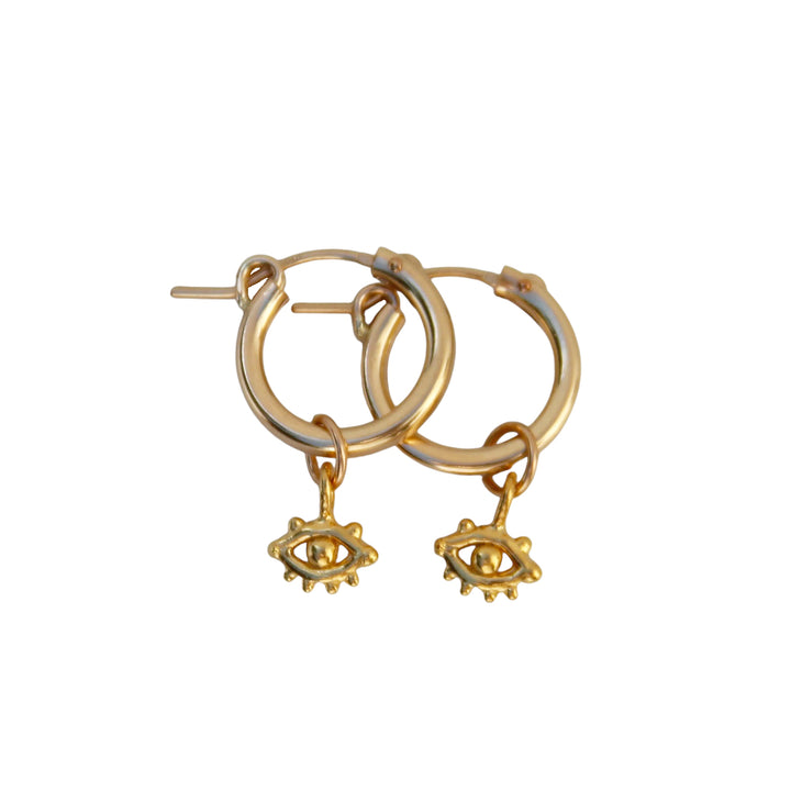 Product image of Eye of Protection Hoop Earrings by Blooming Lotus Jewelry. These gold hoops feature a delicate evil eye charm with intricate detailing, symbolizing protection and positive energy. The minimalist yet meaningful design adds a touch of bohemian style to these unique earrings.