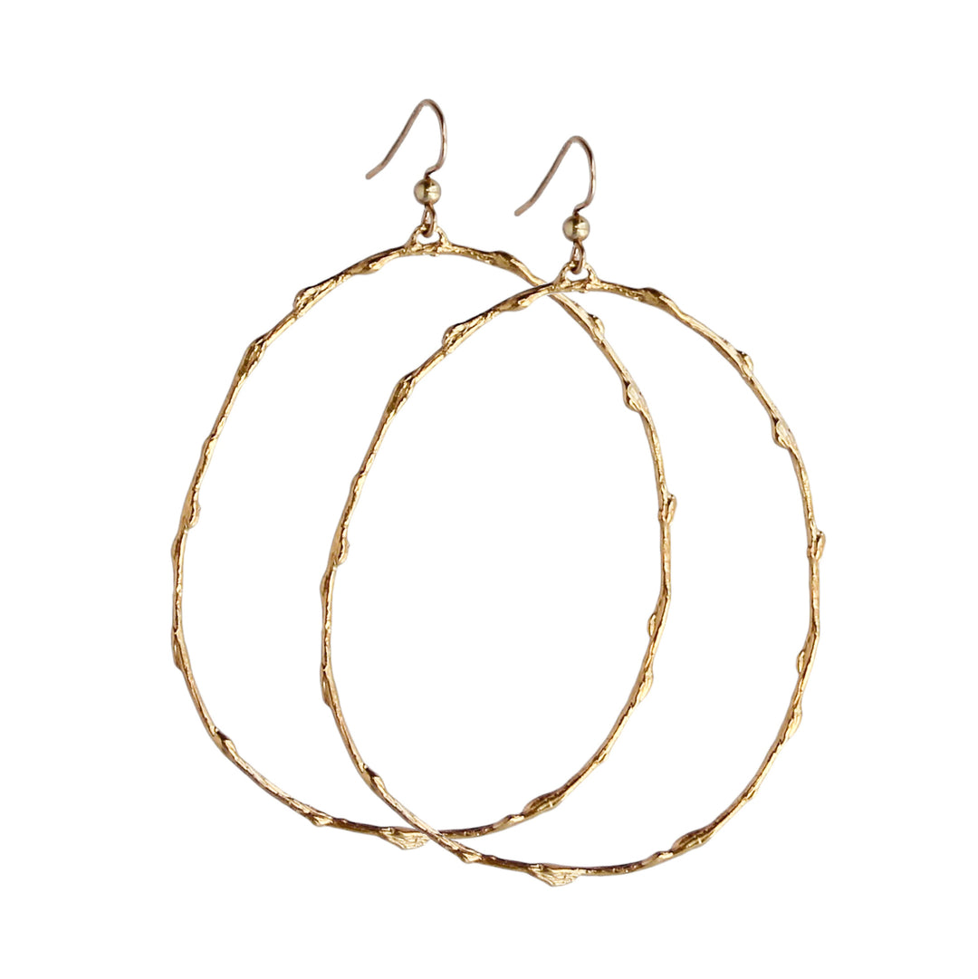 Pair of large gold hoop earrings with a branch-inspired texture, designed in an elongated loop shape