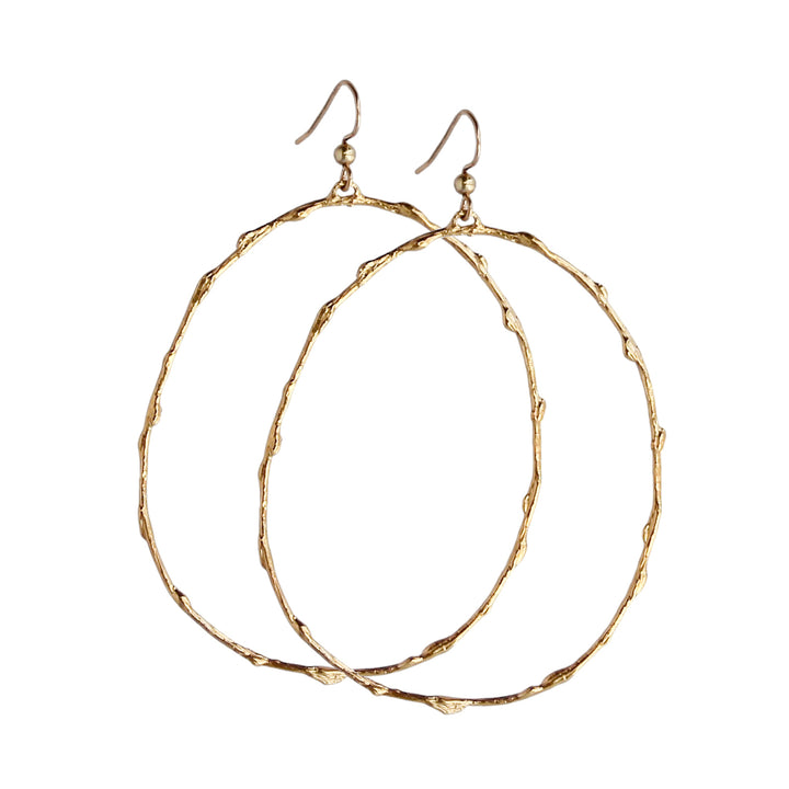 Pair of large gold hoop earrings with a branch-inspired texture, designed in an elongated loop shape