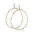 Pair of large gold hoop earrings with a branch-inspired texture, designed in an elongated loop shape