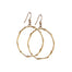 Pair of medium-sized gold hoop earrings with a branch-inspired texture, designed in an elongated loop shape