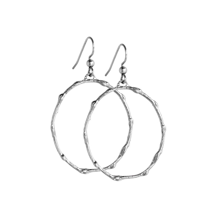 Pair of medium-sized silver hoop earrings with a branch-inspired texture, designed in an elongated loop shape