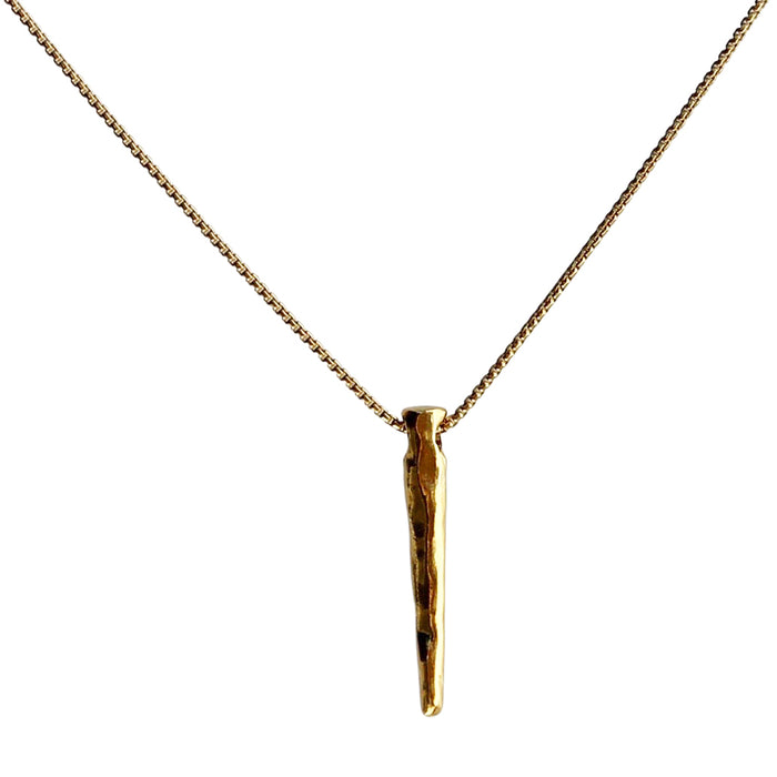 Close-up of a gold necklace featuring a sleek, spear-shaped pendant with a textured finish, hanging from a delicate gold chain, displayed against a white background.