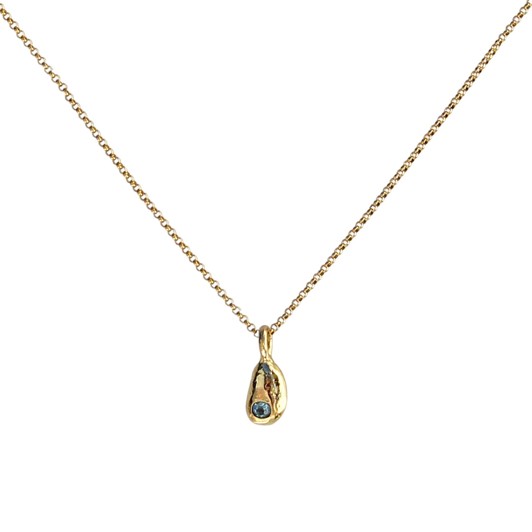 Gold necklace featuring a tiny pebble-shaped pendant cast from a real beach pebble, polished to a shiny finish, and adorned with a sparkling aquamarine birthstone. The pendant hangs delicately on a thin gold chain, showcasing its natural texture and elegant simplicity.