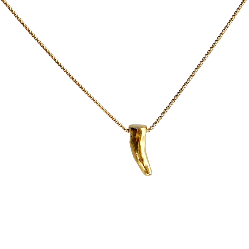 Close-up of a gold necklace featuring a small, polished tusk-shaped charm hanging from a delicate gold chain, displayed against a white background.