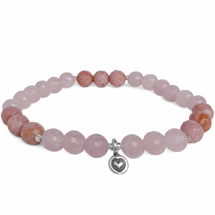 Close-up image of the Choose Love Bracelet featuring faceted rose quartz and rhodonite gemstone beads. The bracelet is accented with a tiny silver heart charm, symbolizing love and compassion. 