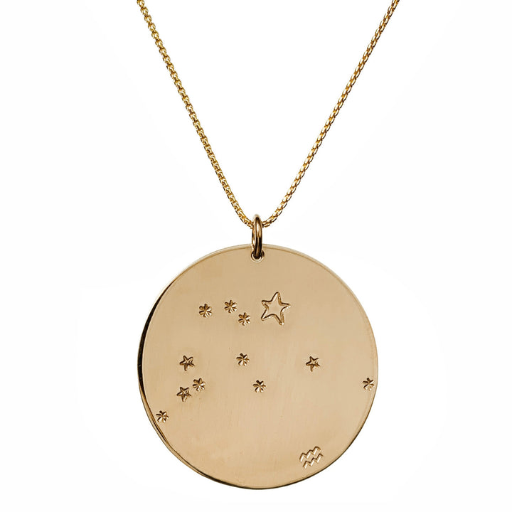 Close-up product photo of the Large Constellation Necklace in gold, featuring the Aquarius zodiac constellation stamped with star and dot patterns on a circular pendant, hanging from a gold chain. Perfect for a personalized and celestial-inspired jewelry statement.