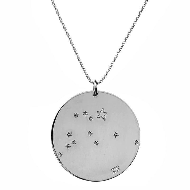 Close-up product photo of the Large Constellation Necklace in silver, featuring the Aquarius zodiac constellation stamped with star and dot patterns on a circular pendant, hanging from a silver chain. Perfect for a personalized and celestial-inspired jewelry statement.