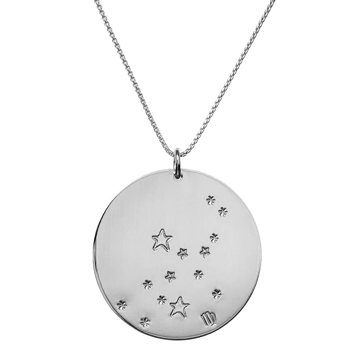 Close-up product photo of the Large Constellation Necklace in silver, featuring the Virgo zodiac constellation stamped with star and dot patterns on a circular pendant, hanging from a silver chain. Perfect for a personalized and celestial-inspired jewelry statement.