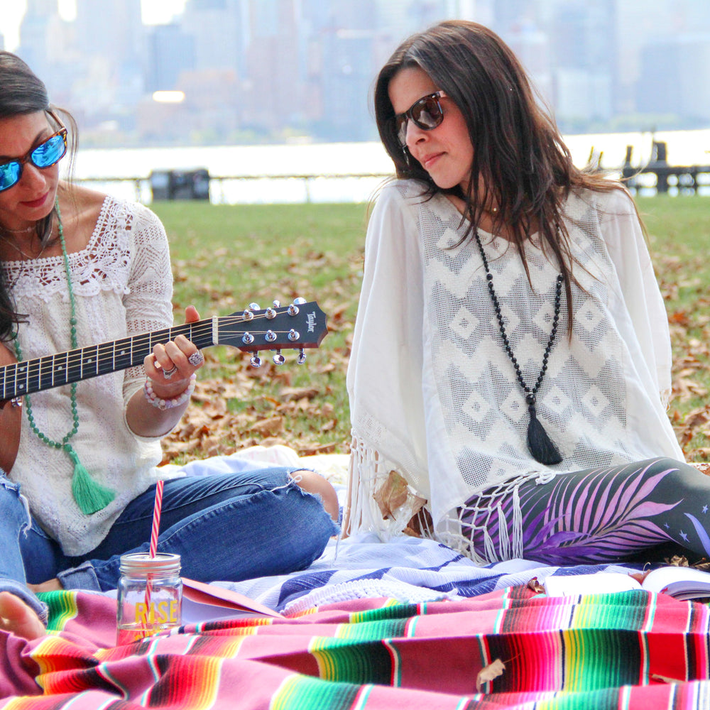 Eclipse Mala necklace on model sitting on picnic blanket guitar - Blooming Lotus Jewelry