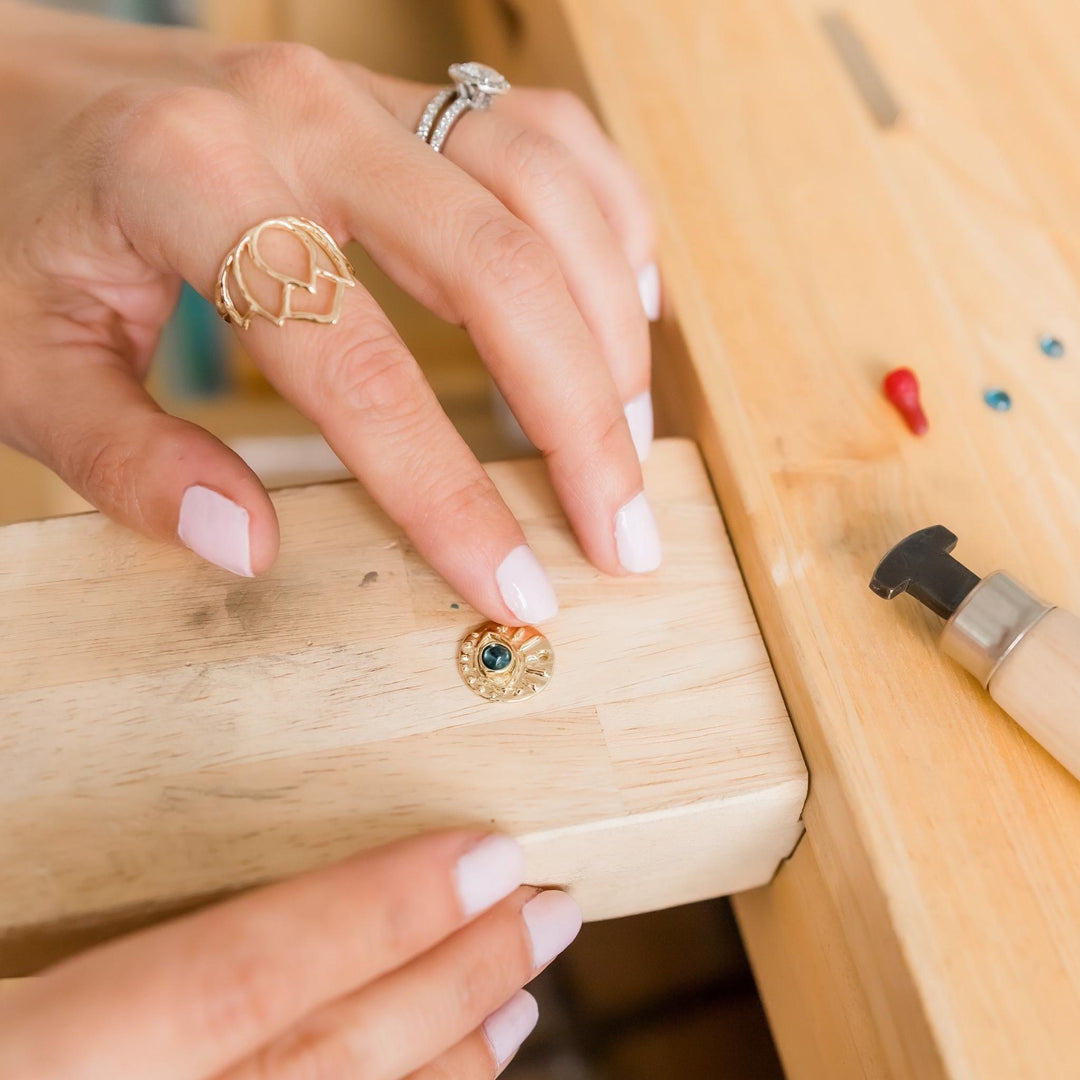 Gold Eye of Protection on jeweler's bench with Topaz - Blooming Lotus Jewelry