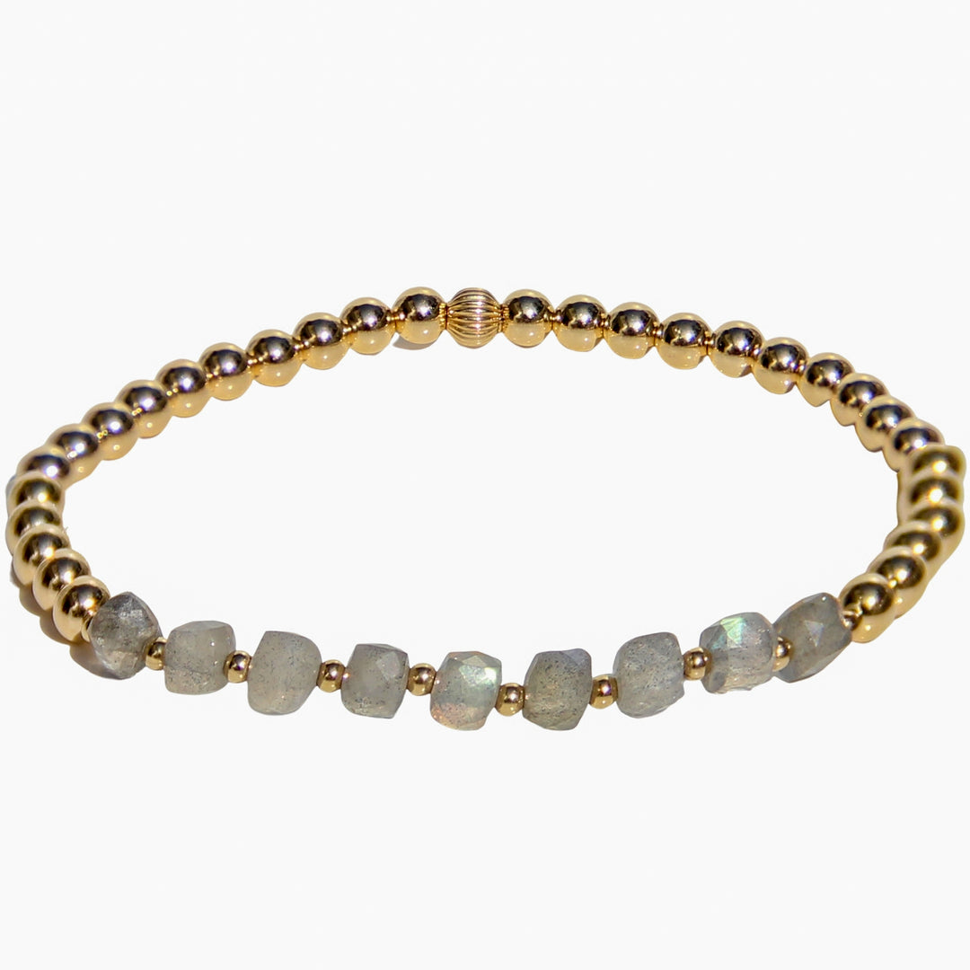 Gold beaded stretch bracelet featuring cube faceted labradorite gemstones with flashes of iridescent blue and gray. A mystical and meaningful gemstone bracelet for intuition, transformation, and inner strength.