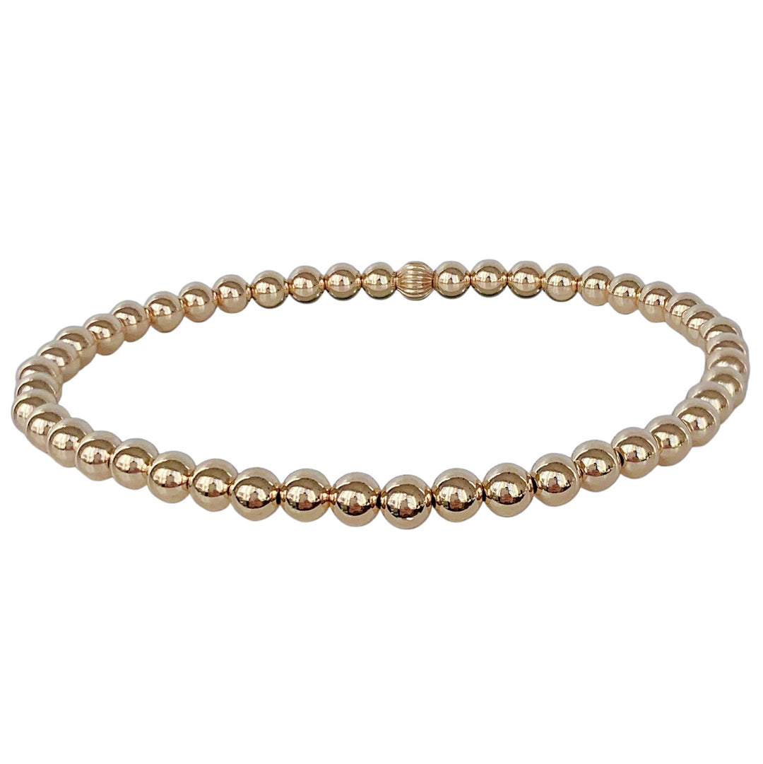 Simple gold beaded stretch bracelet featuring polished 4mm gold beads. A timeless and versatile piece, perfect for stacking or wearing solo for a minimalist look.