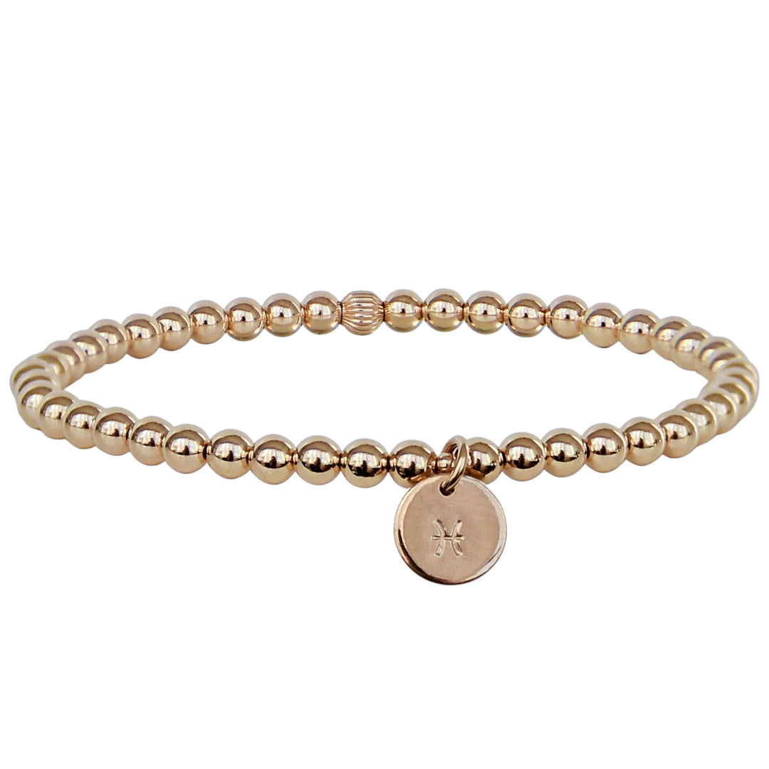 Gold beaded bracelet featuring a round charm hand-stamped with the Pisces zodiac symbol. The bracelet showcases polished, reflective beads and a sleek, minimalist design perfect for everyday wear.