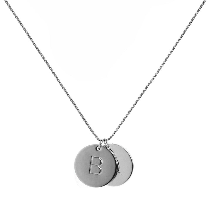 Silver hand-stamped initial disc necklace featuring two personalized pendants on a silver chain, perfect for custom gifts and everyday wear. Handmade by Blooming Lotus Jewelry