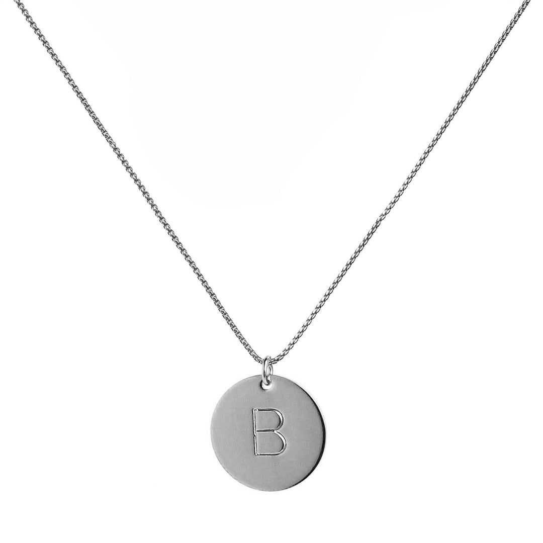 single silver initial disc coin pendant hanging from silver chain hand-stamped with capital B