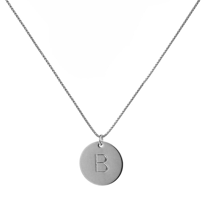 single silver initial disc coin pendant hanging from silver chain hand-stamped with capital B