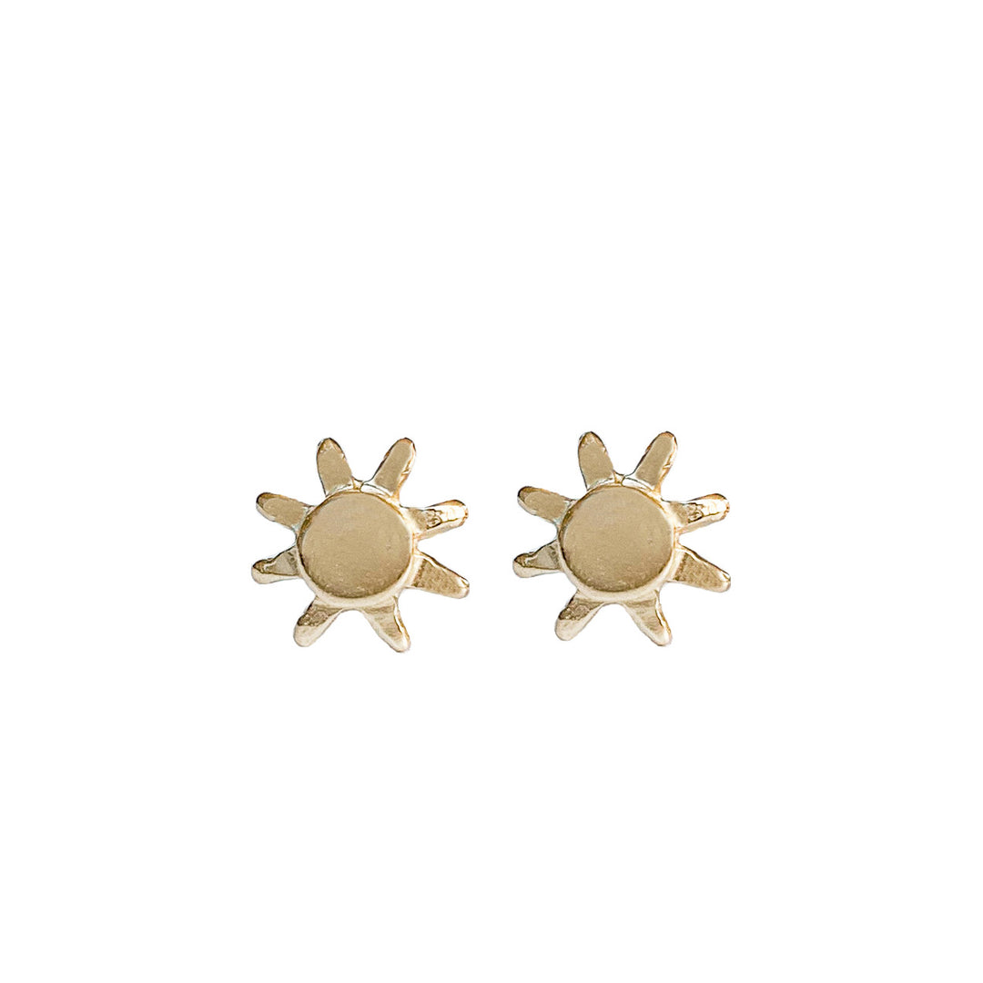 A pair of 14k gold sun-shaped stud earrings with a polished finish, featuring a circular center and delicate rays extending outward. The minimalist yet radiant design makes them perfect for everyday wear or a subtle touch of sunshine-inspired elegance. By Blooming Lotus Jewelry