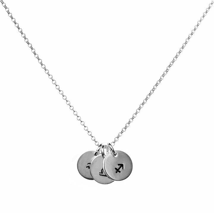 Silver necklace featuring three small round pendants hjand-stamped with zodiac symbols for Sagittarius, Libra, and Aquarius, hanging delicately from a fine chain for a personalized and astrological-inspired design.